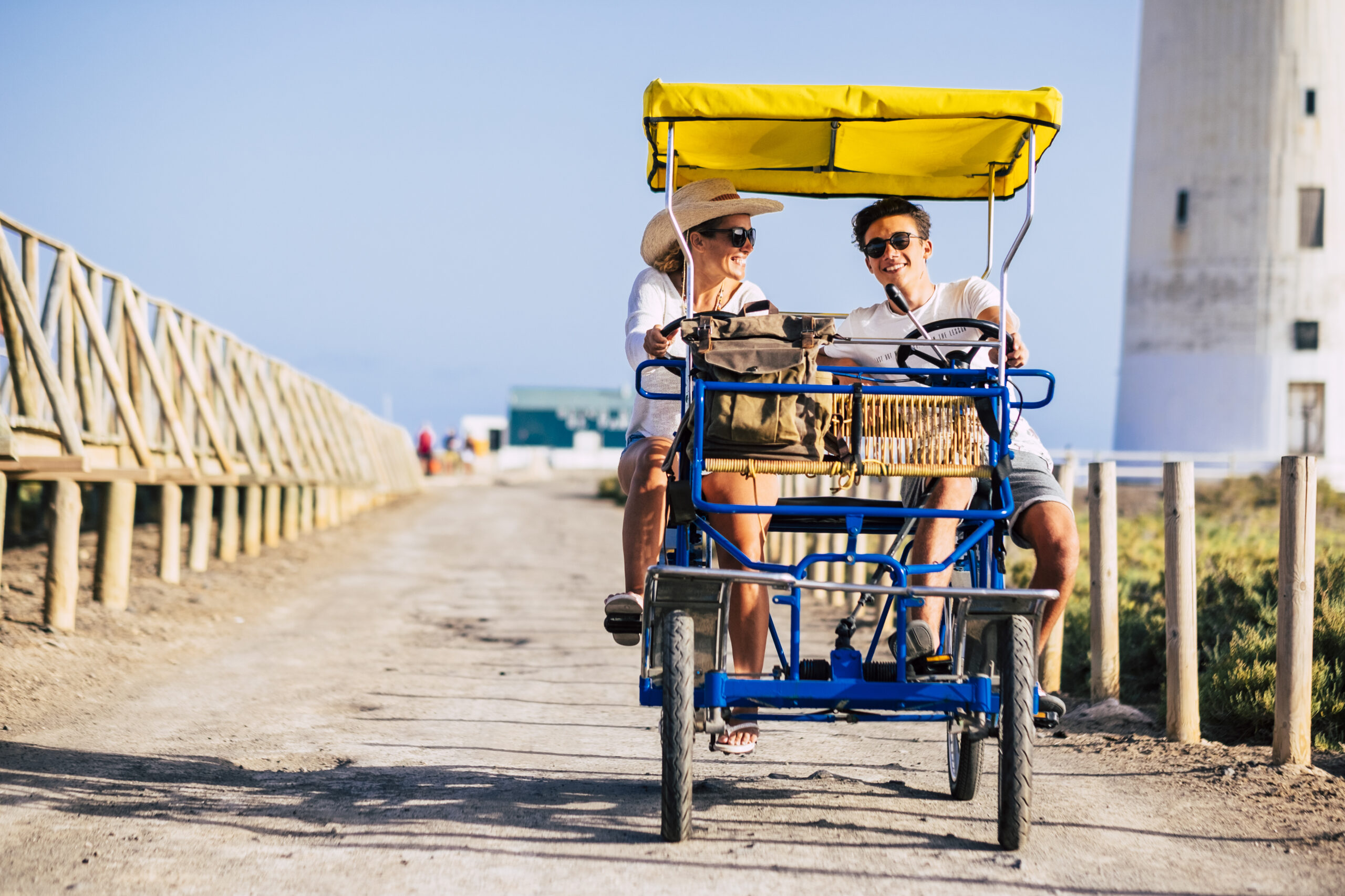 Happy family couple mother and teenager son have fun together on a car vehicle bike in outdoor leisure activity laughing a lot - cheerful people mixed generations