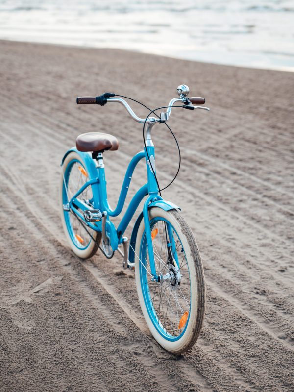 Light-blue bicycle on the beach with the sea on the background